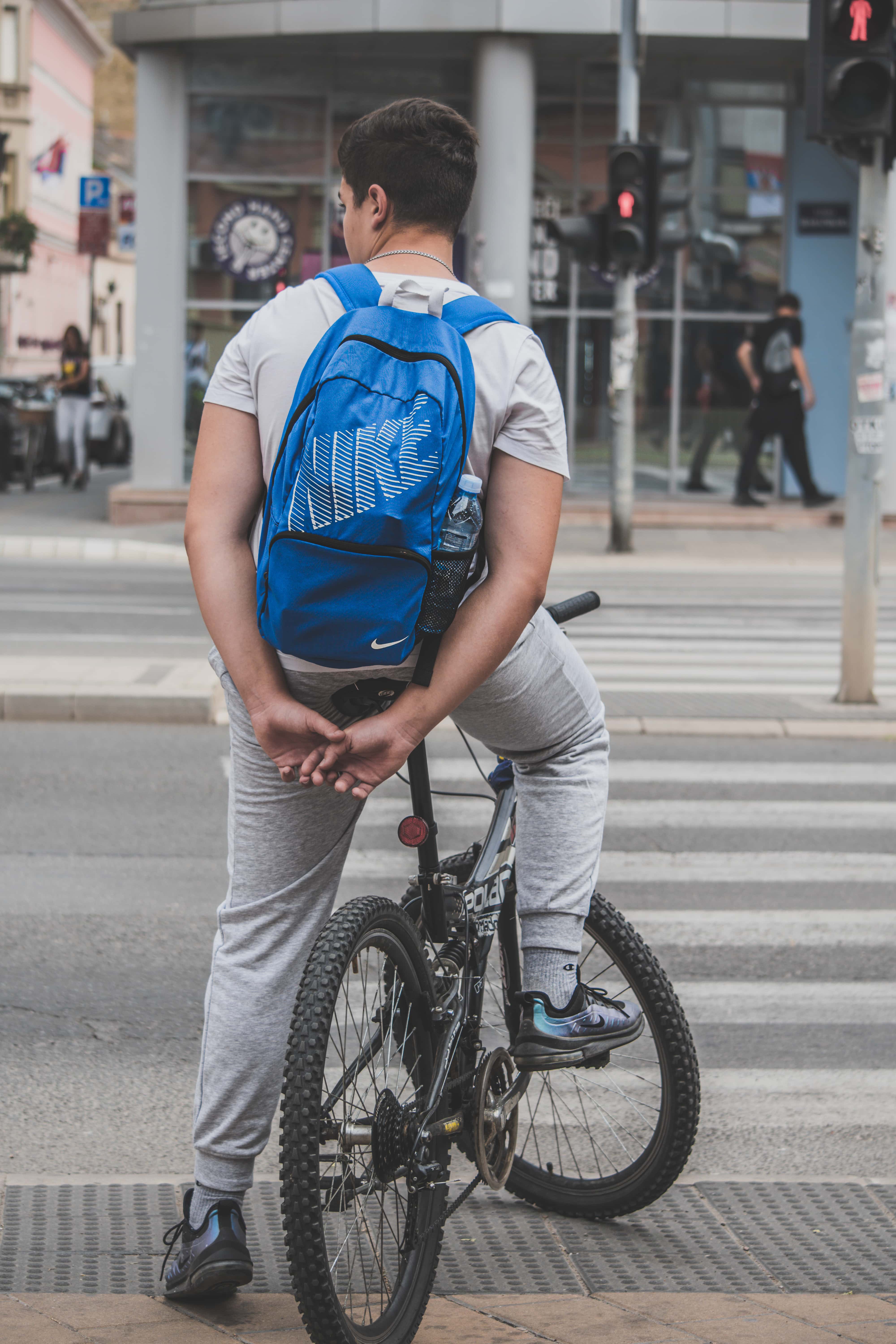 Cyclists waiting for traffic to pass at designated crosswalk.